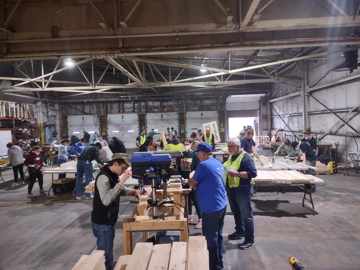 Volunteers drilling and assembling bunk-bed frames